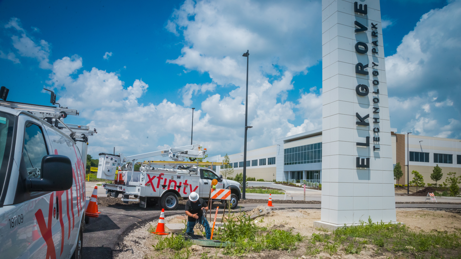 Xfinity vans and equipment parked next to a sign for Elk Grove.