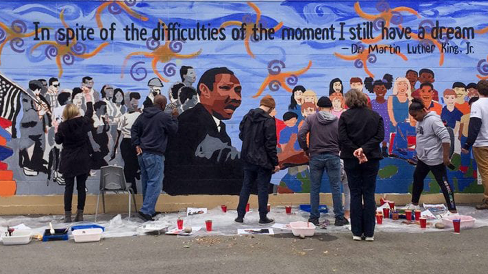 Community members painting a mural of Dr. Martin Luther King, Jr.