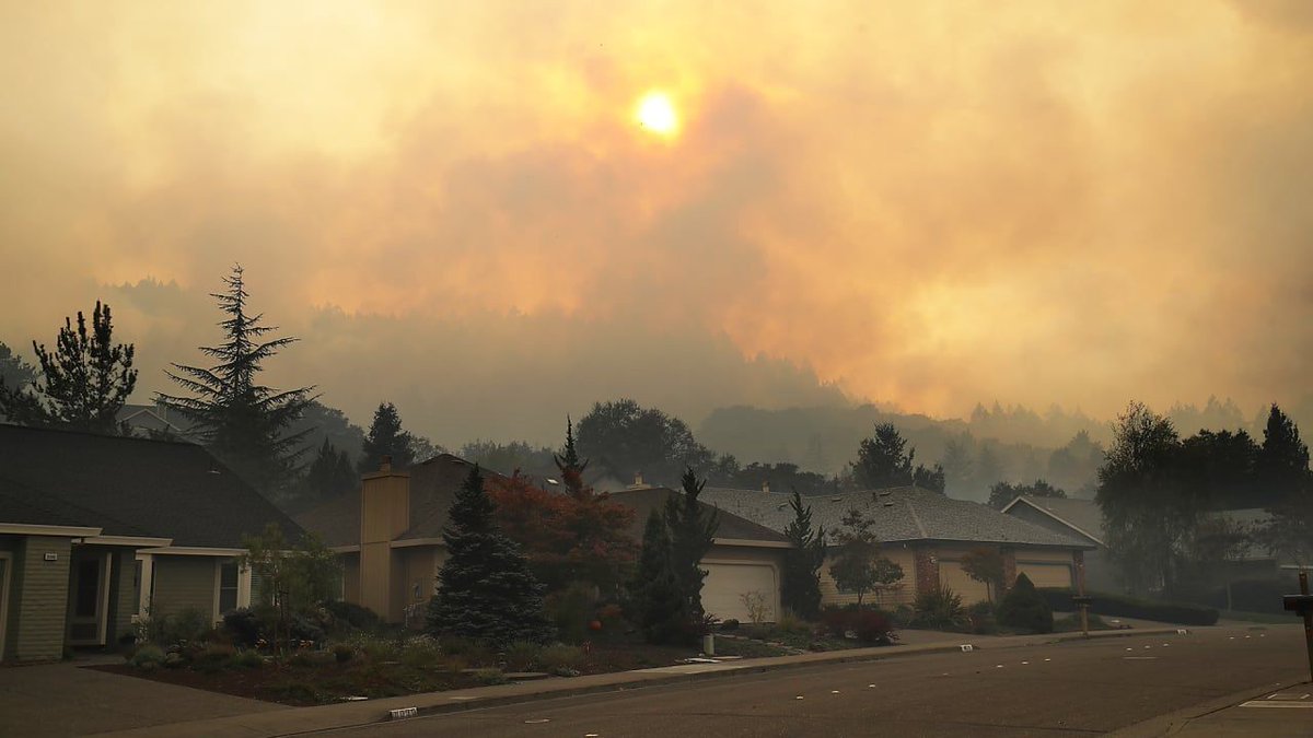 A California neighborhood with clouds of smoke in the sky