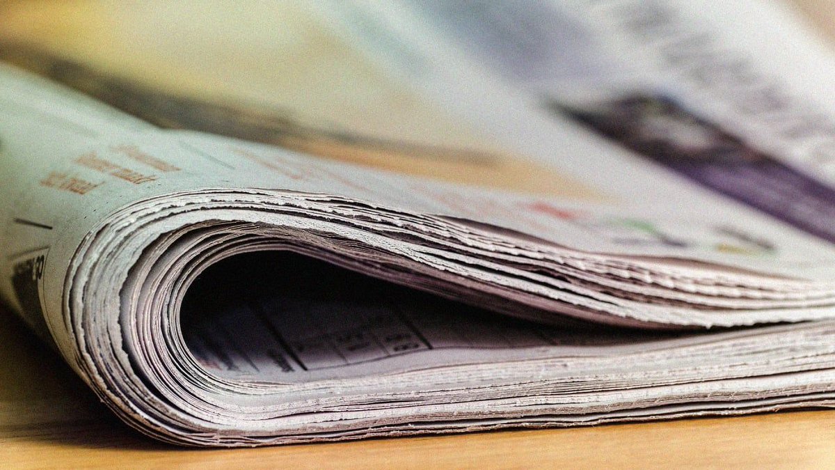 A folded newspaper on a desk.