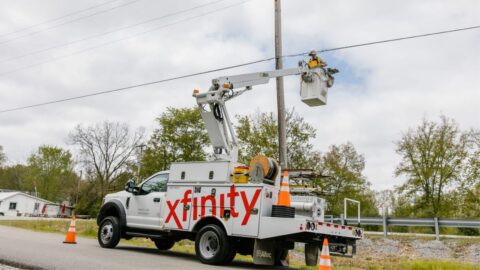 Xfinity truck parked near a post in a rural community