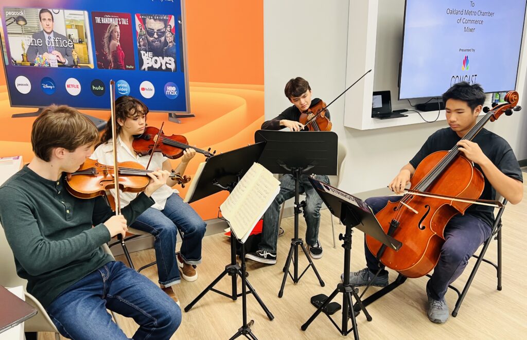 Oakland School of the Arts string quartet plays live music at Oakland Metro Chamber Reception at the Xfinity store on Broadway