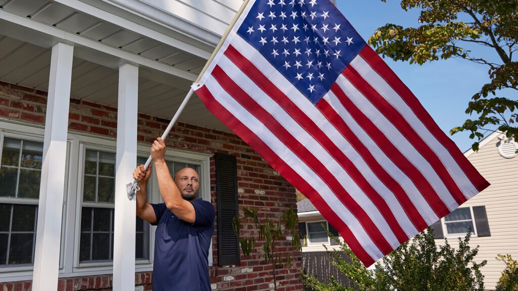 A Comcast team member preparing an American flag to be hung.