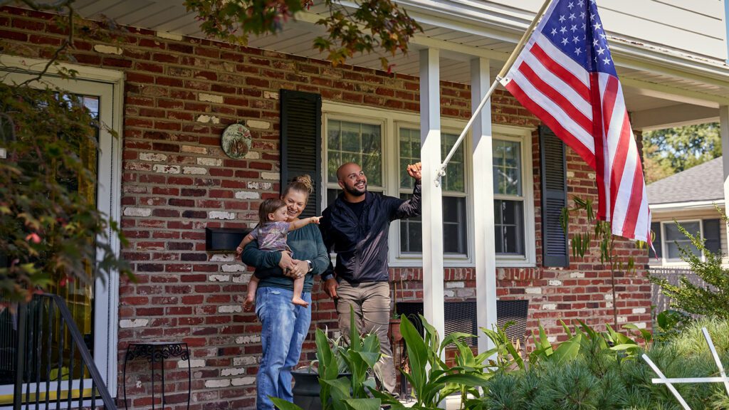 A Comcast team member and his family observing an American flag.