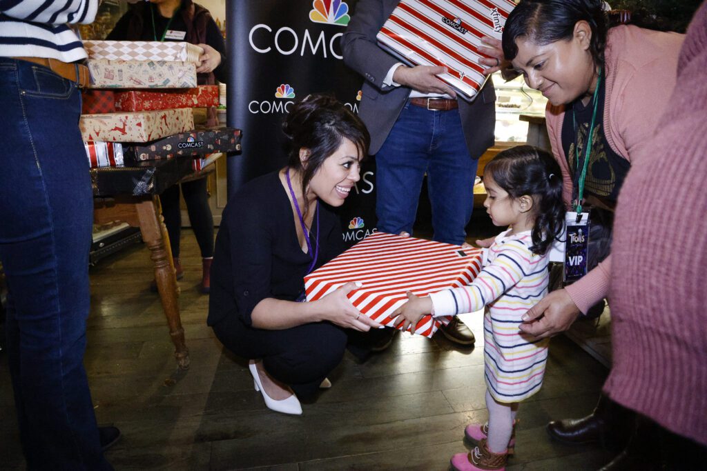 Marcy Flores, Executive Director or Corazon Healdsburg, gives a young girl a free laptop donated by Comcast California.