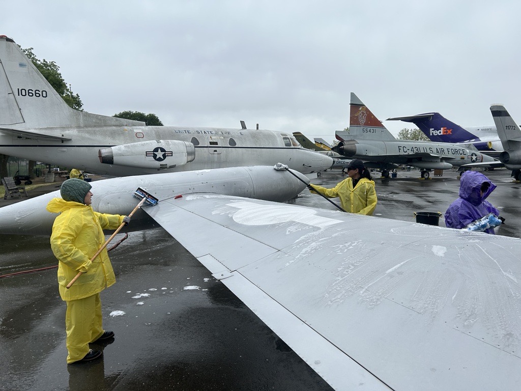 Comcast employees volunteer and wash aircrafts at the Aerospace Museum of California