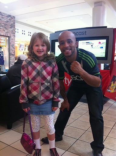 UFC fighter Mighty Mouse posing with a fan