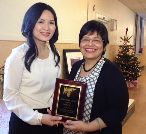 Estela Ortega, right, executive director of El Centro de La Raza in Seattle, presented the Corporate Citizen of the Year Award to Comcast in Seattle. Receiving the award was Diem Ly, left, manager of external affairs for Comcast in Washington.