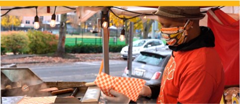 A man prepares food on an outdoor grill.