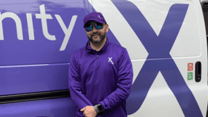 Grant Morris stands in front of a purple Xfinity van.