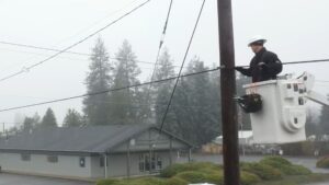 A Comcast technician works on a cable on a power line.