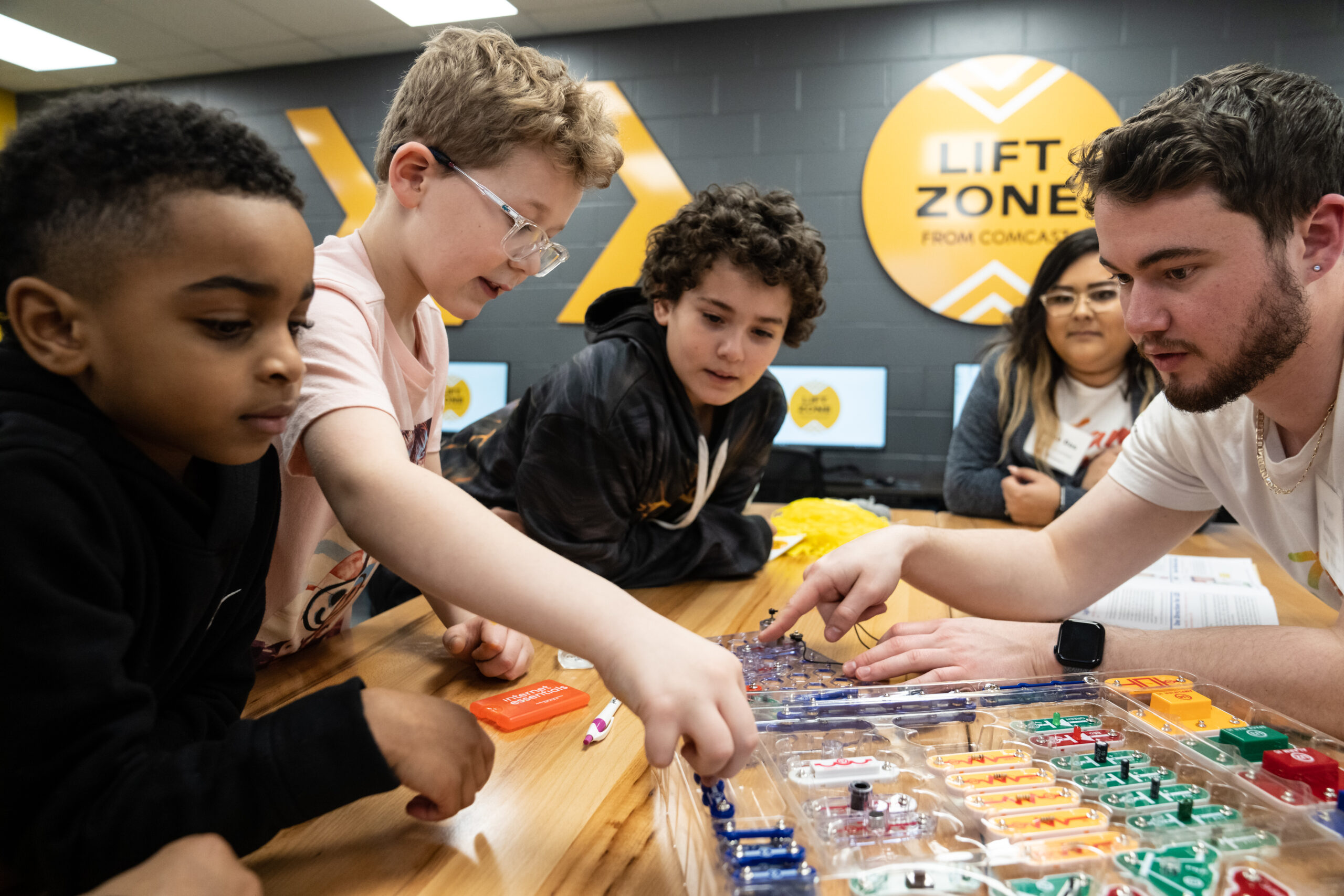 Children work with a STEM kit in the Enhanced Lift Zone. 