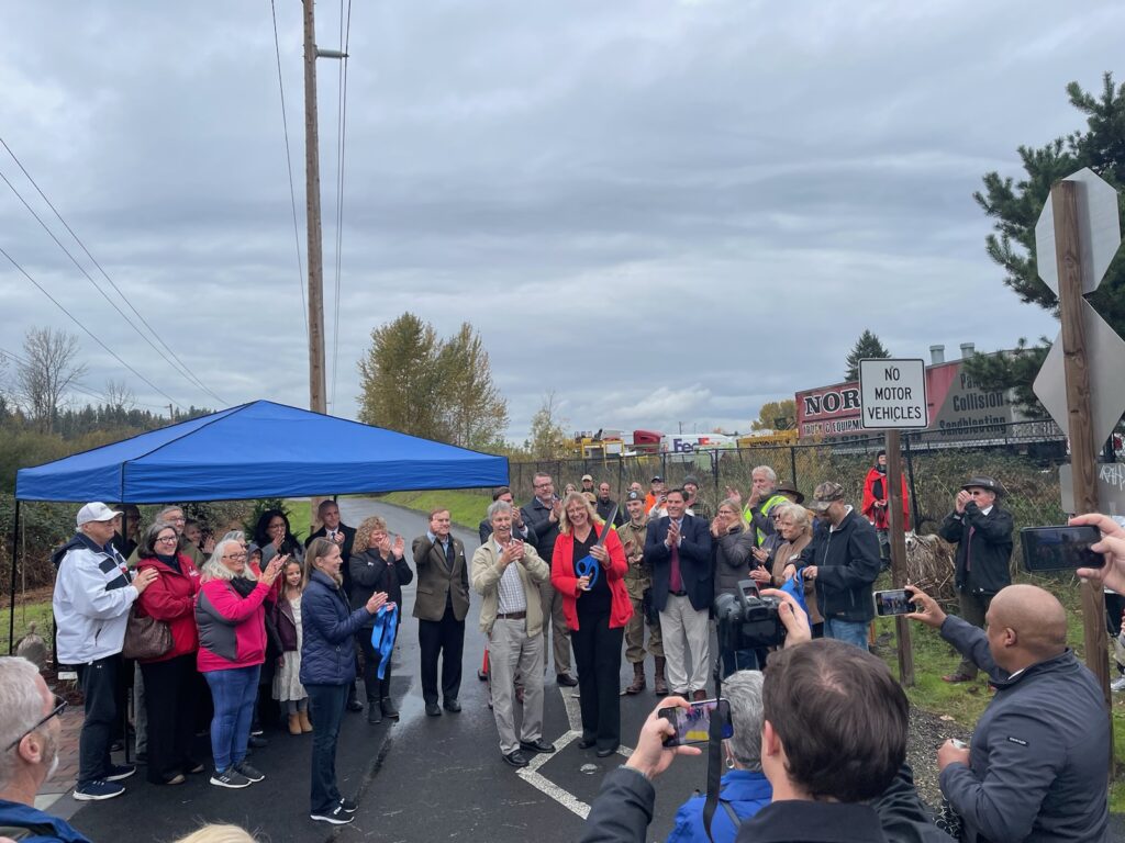 Mayor Guier cuts ribbon at the memorial with volunteers.