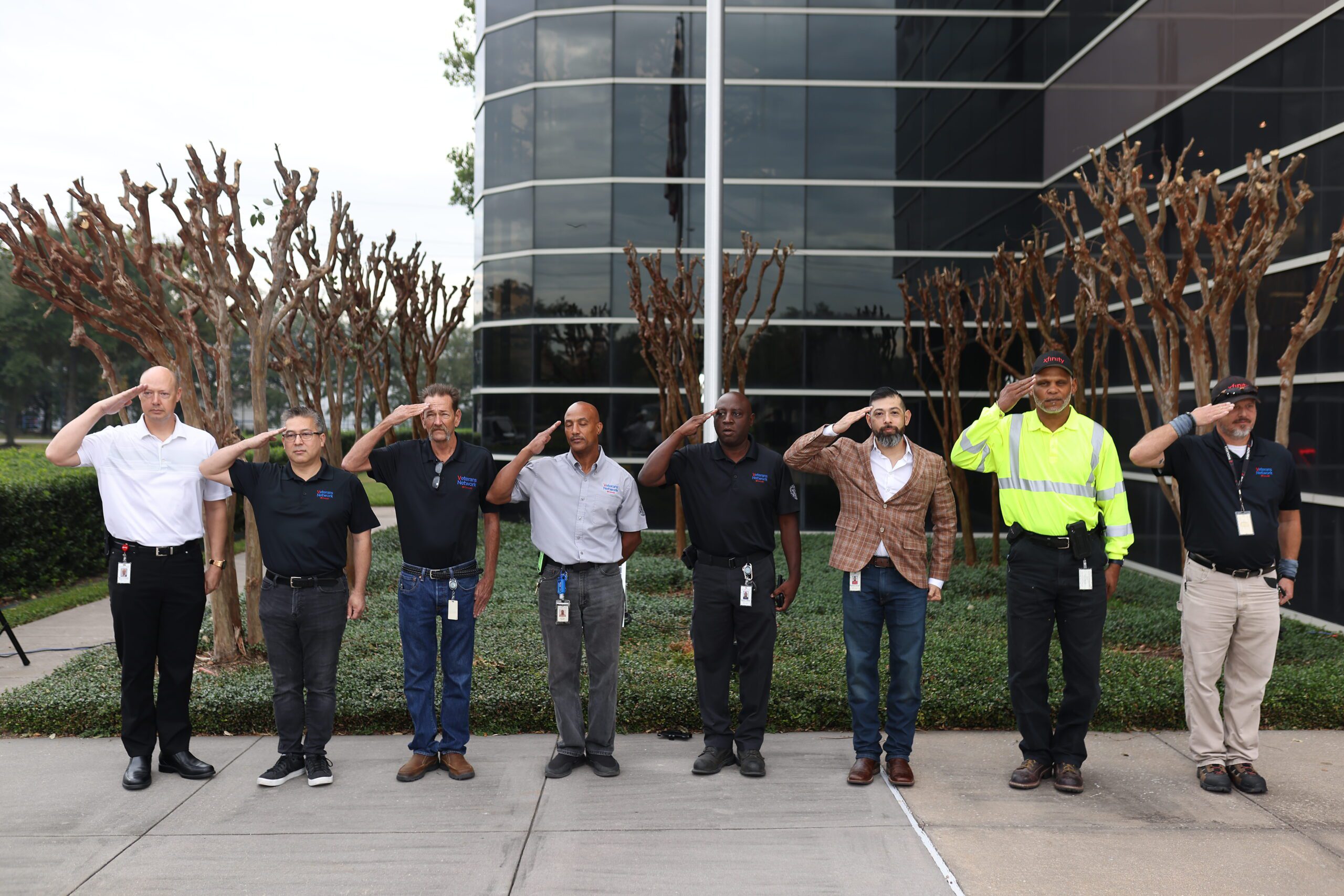Eight members of Comcast's Veteran's Network saluting.