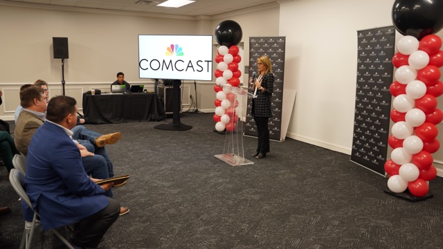 Comcast’s Toni Beck speaking to seated crowd