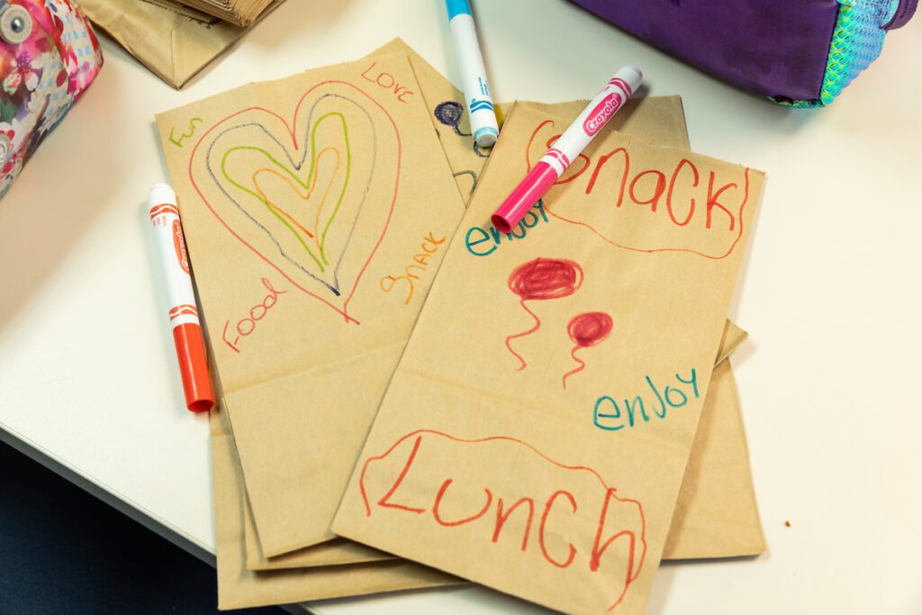 Close up of paper bags with drawings and notes on them