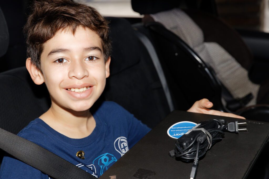 Young boy smiling and holding gaming console