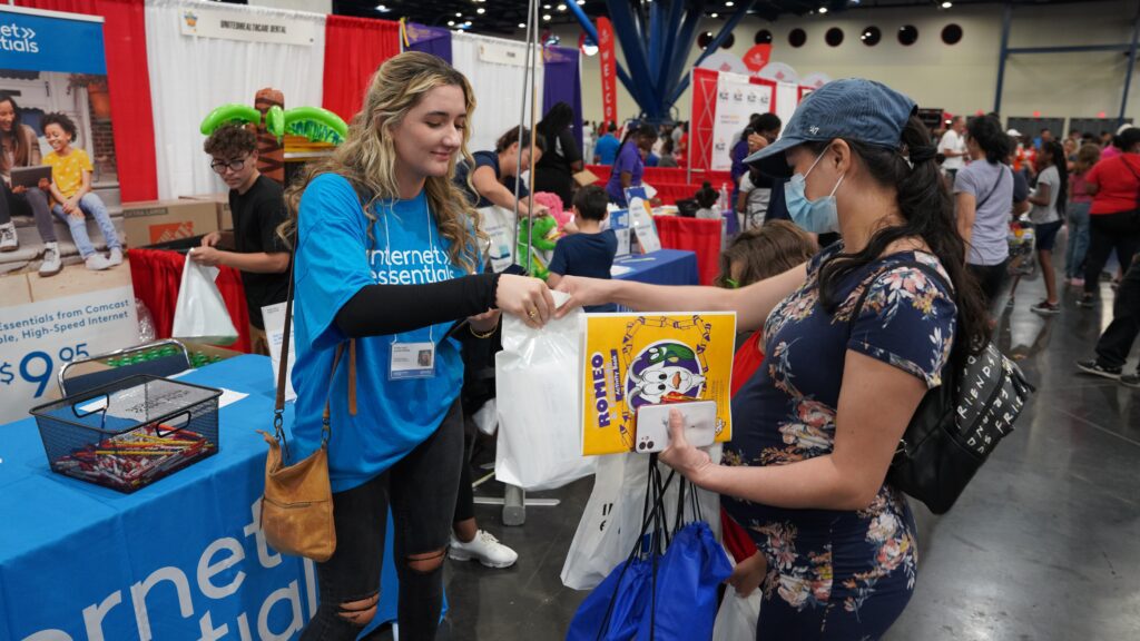 Volunteer handing a woman an Internet Essentials bag