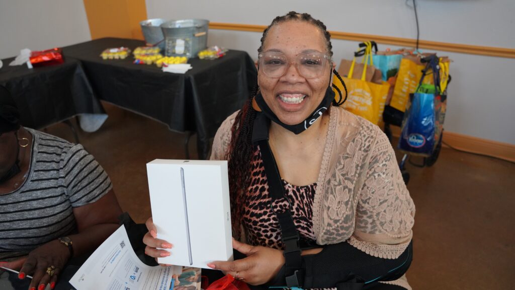 Smiling woman holding an iPad box