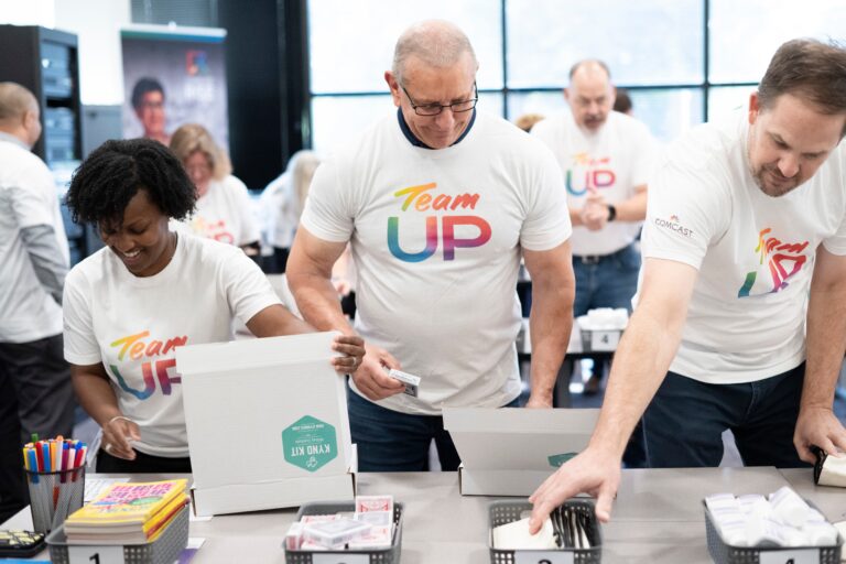 Chef Robert Irvine and Comcast volunteers are pictured together. They're packing gratitude kits for veterans.