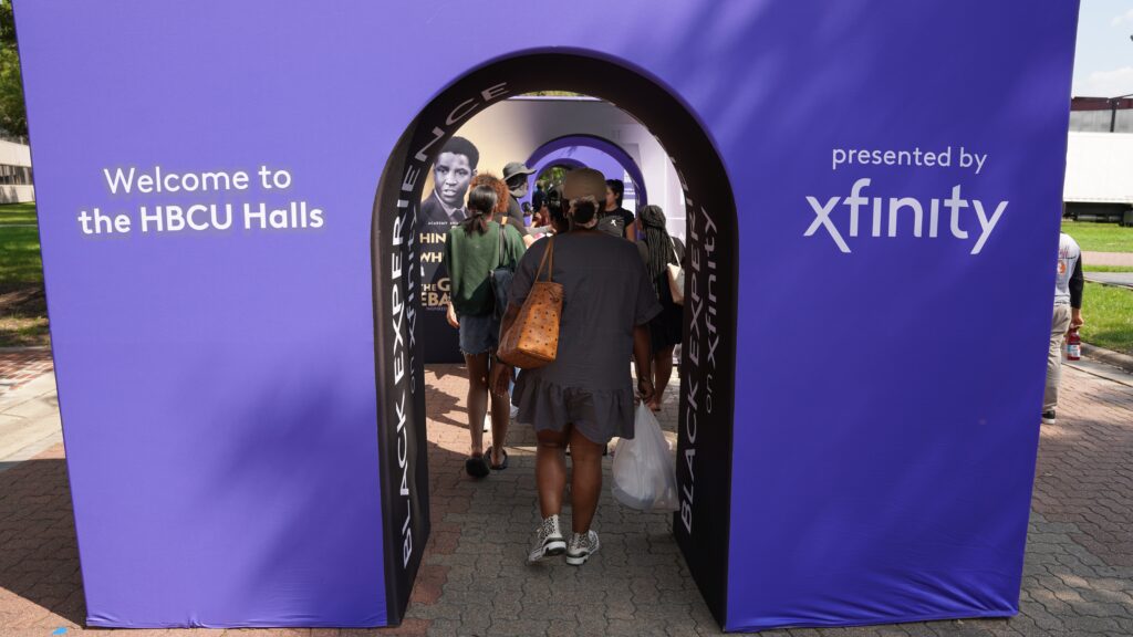 Person walking through Purple Xfinity Archway