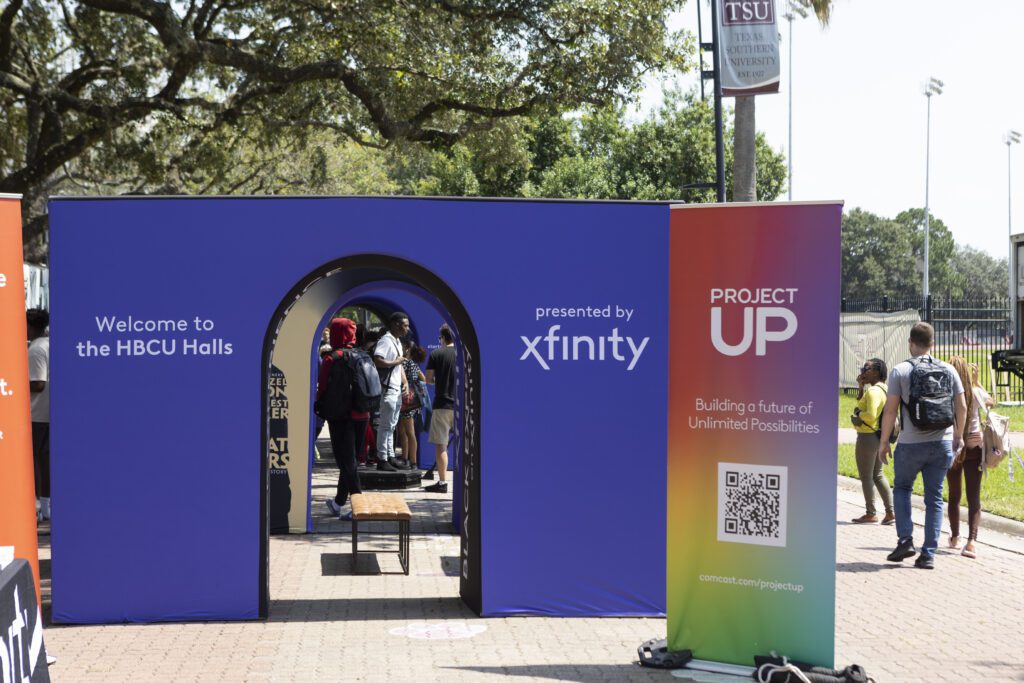 Large purple Xfinity archway and Project Up sign with QR code