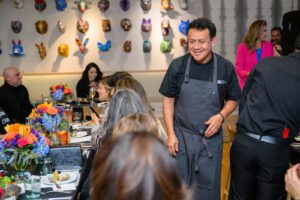 Chef Ortega smiling and looking at table of guests