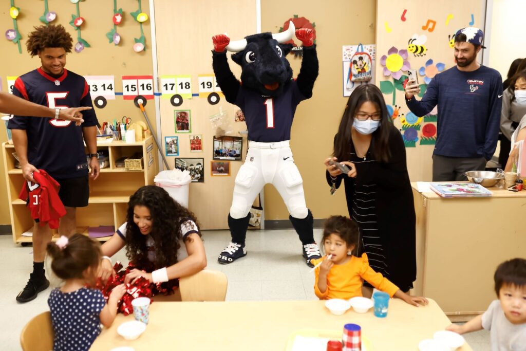 Mascot and volunteers entering toddler classroom