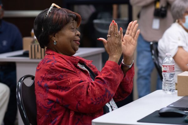 A woman claps at a digital skills learn session.