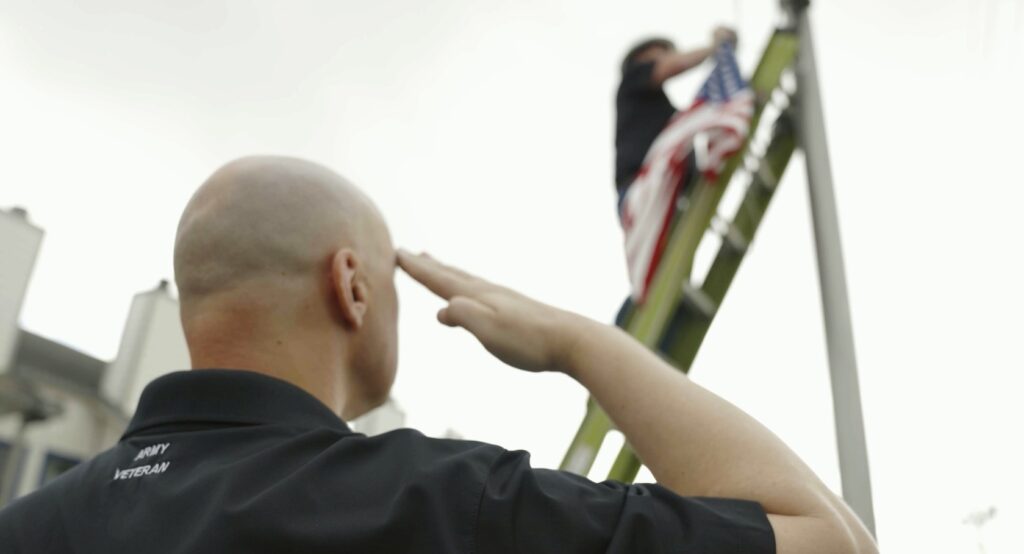 Comcast employee and veteran Brian Wright salutes the American Flag at Comcast Texas' first flag replacement event in southwest Houston.