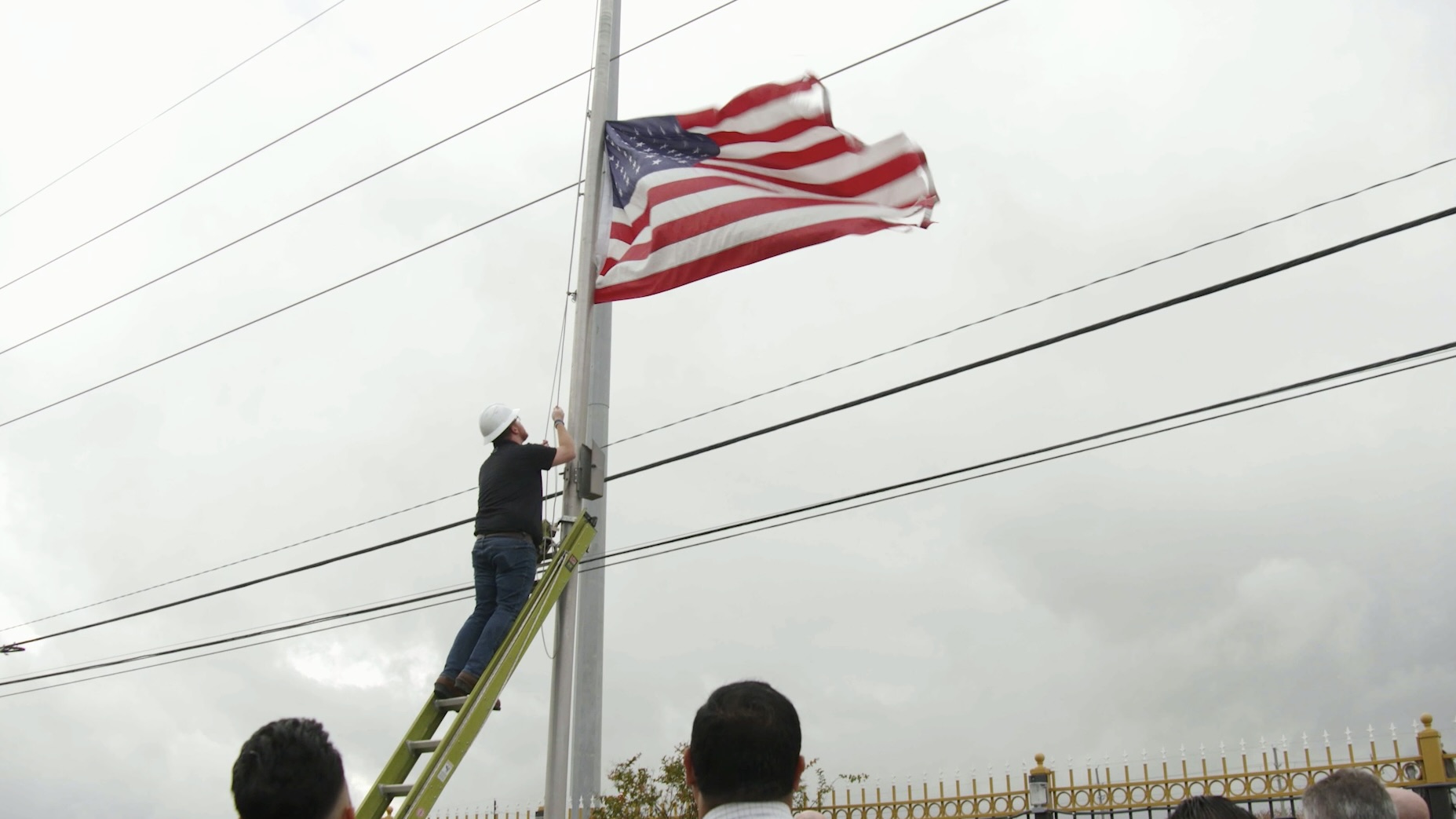 A veteran who is also a Comcast Texas employee takes down a worn American Flag.