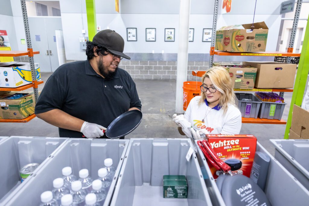 Volunteers adding pans to bins at Houston food bank.