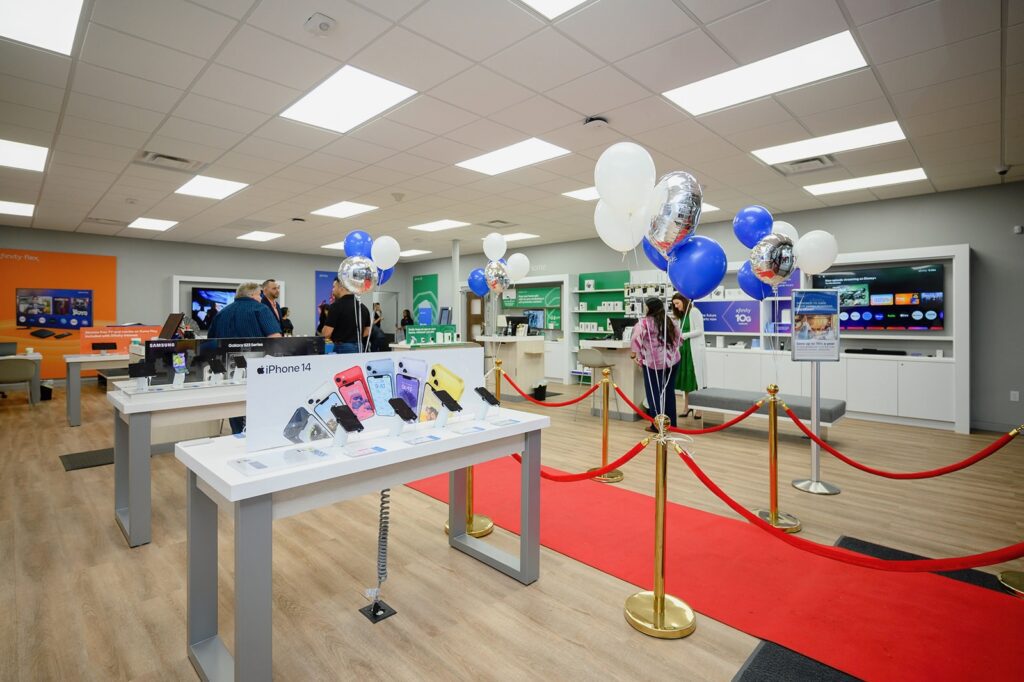 Image inside the store showing tables and a red carpet all decorated with blue and white balloons 
