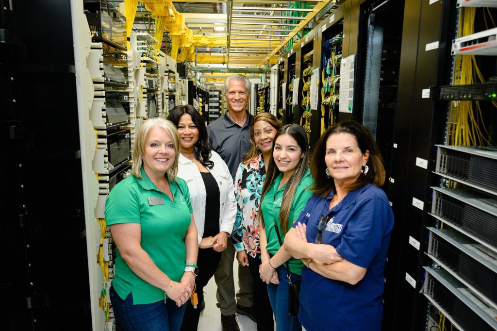 Guests posing for picture inside server room.
