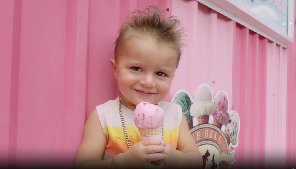 Young girl smiling and holding up ice cream cone