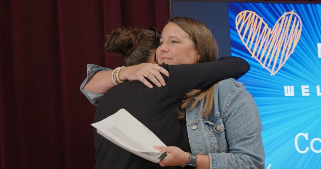 Colleague hugs Nicole Covert after reading letter