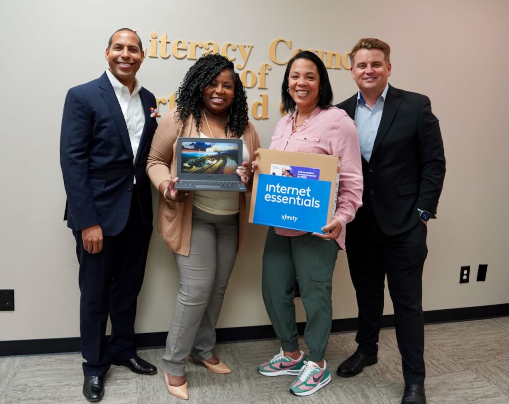 Members of the Literacy Council of Fort Bend County hold laptops from Comcast.