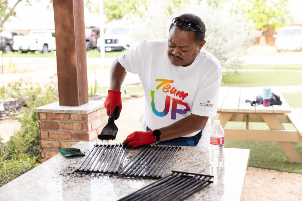 Volunteer cleans the outdoor kitchen at Camp Hope.