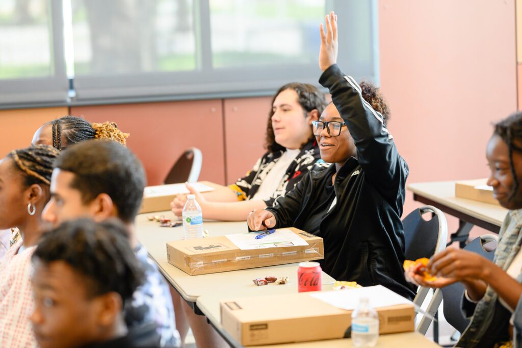 A student raises her hand during a resume building class.