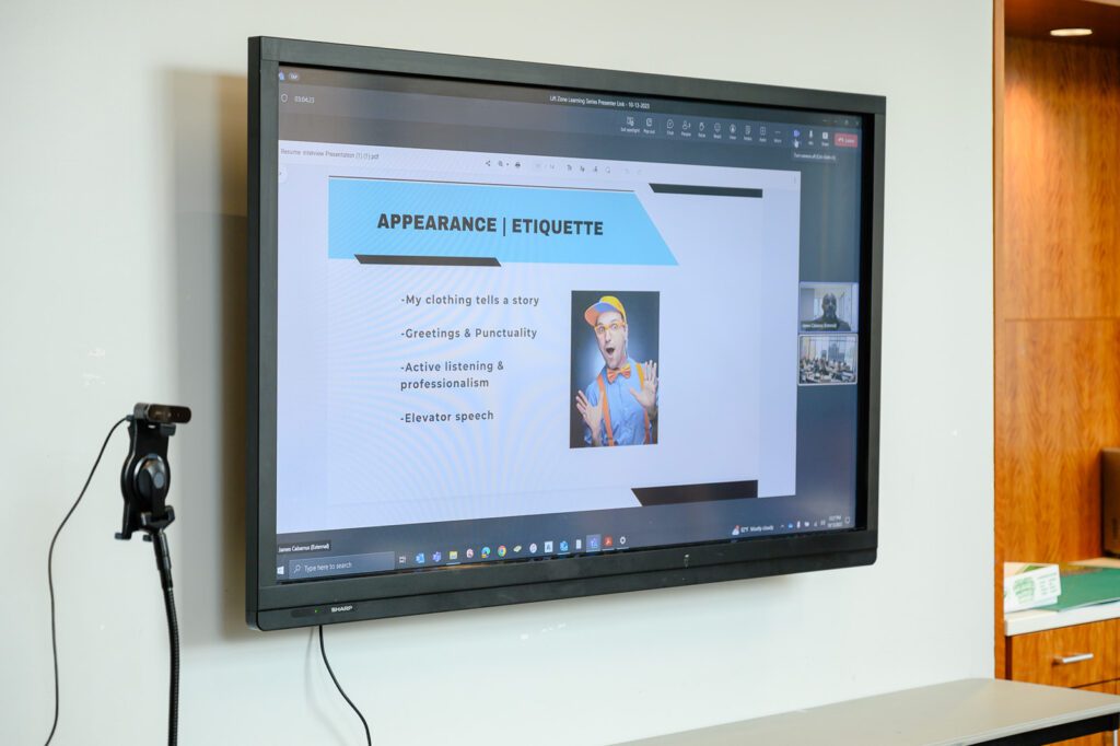 A powerpoint slide is displayed on a monitor during the learning session.