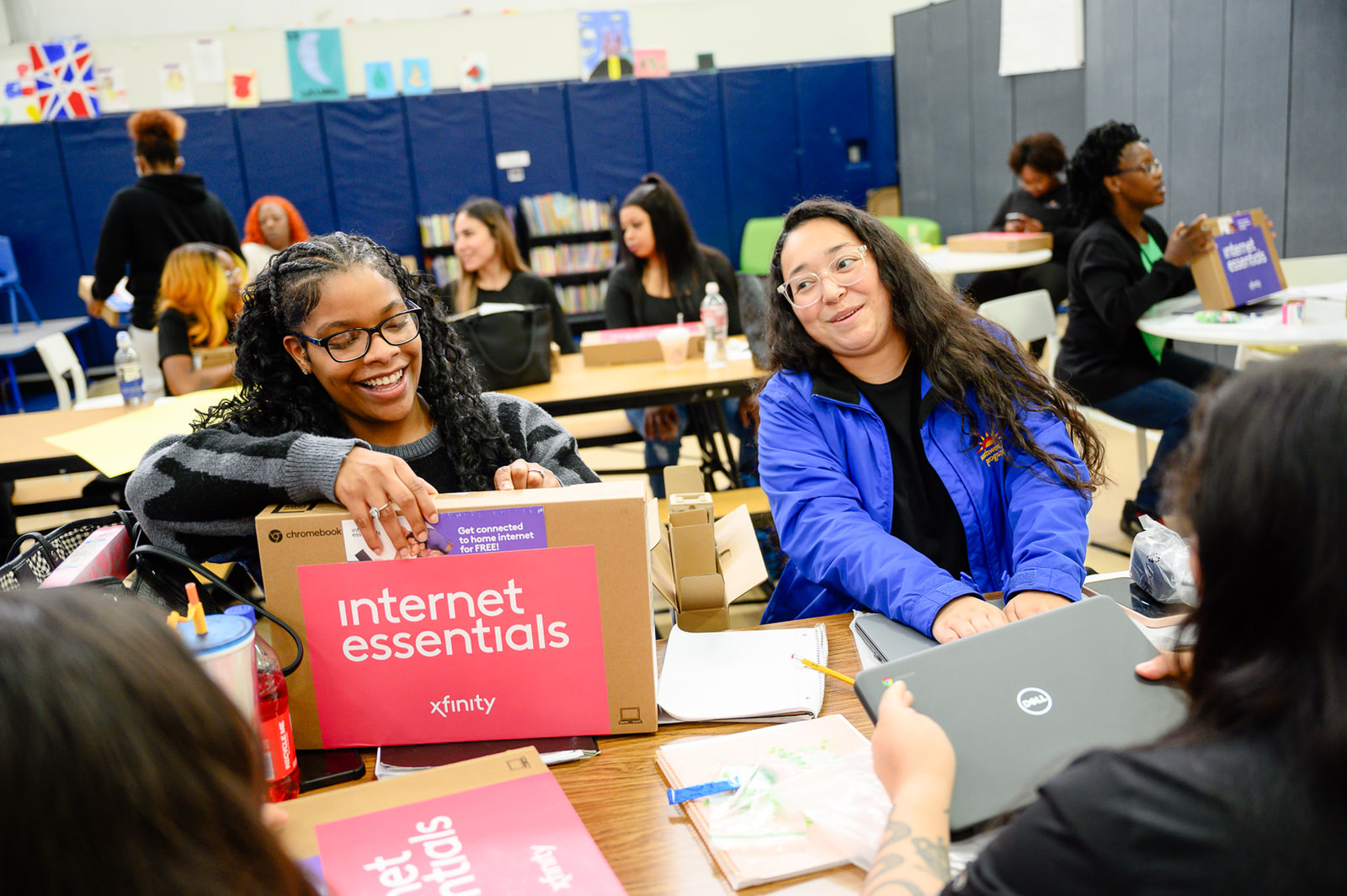 People smile with new laptops at a Comcast event celebrating Digital Inclusion Week.