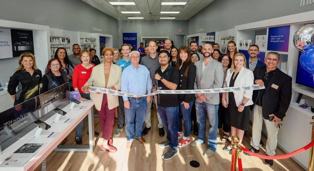 People gather for a photo in front of a ribbon cutting at an Xfinity store in Pearland, Texas.