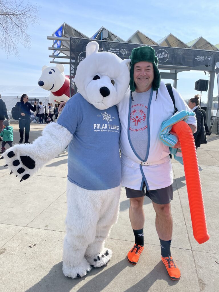 Jason Martin, dressed as Cousin Eddie poses with the Polar Plunge Mascot before his jump