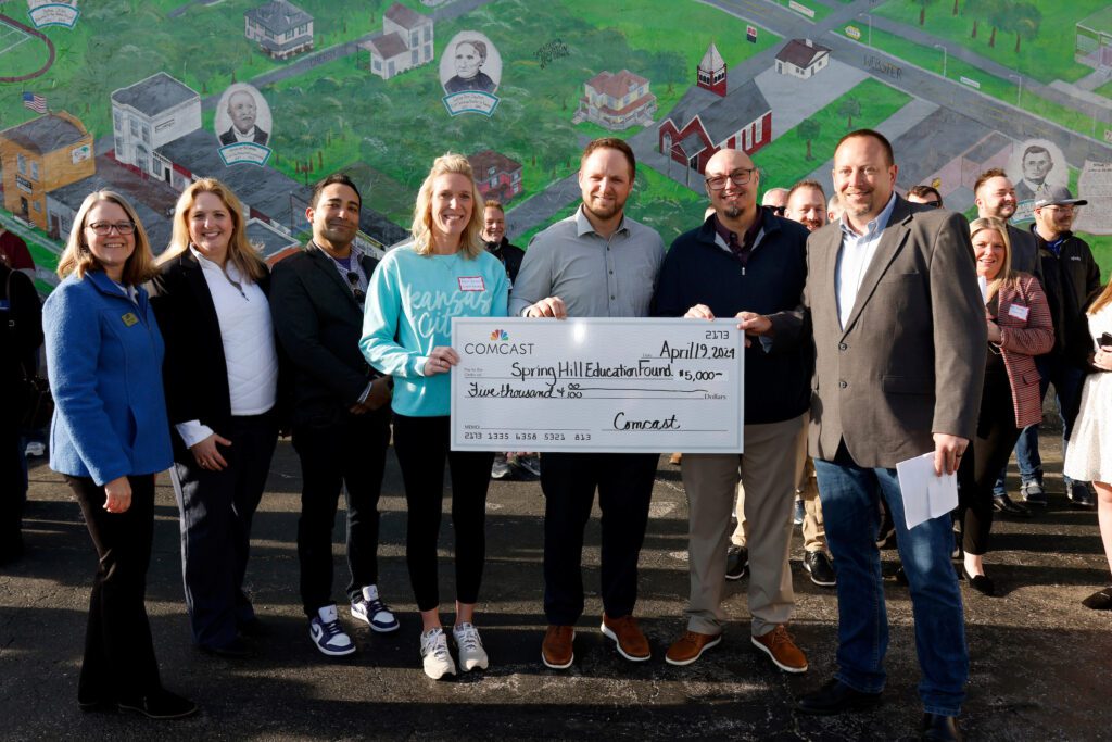 Chamber of Commerce President Sharon Mitchell, Comcast Senior Manager, Meghan Shea, Comcast Director of Sales and Marketing, Andres Florez, Spring Hill Education Foundation board members, April Erhart and Grant Euwing, Foundation president, BJ Harris, and Jay Gottman, Comcast Midwest Region, Director of Sales and Marketing, participate in a check presentation at the Spring Hill Chamber of Commerce on Friday, April 19, 2024 in Spring Hill, Kan.