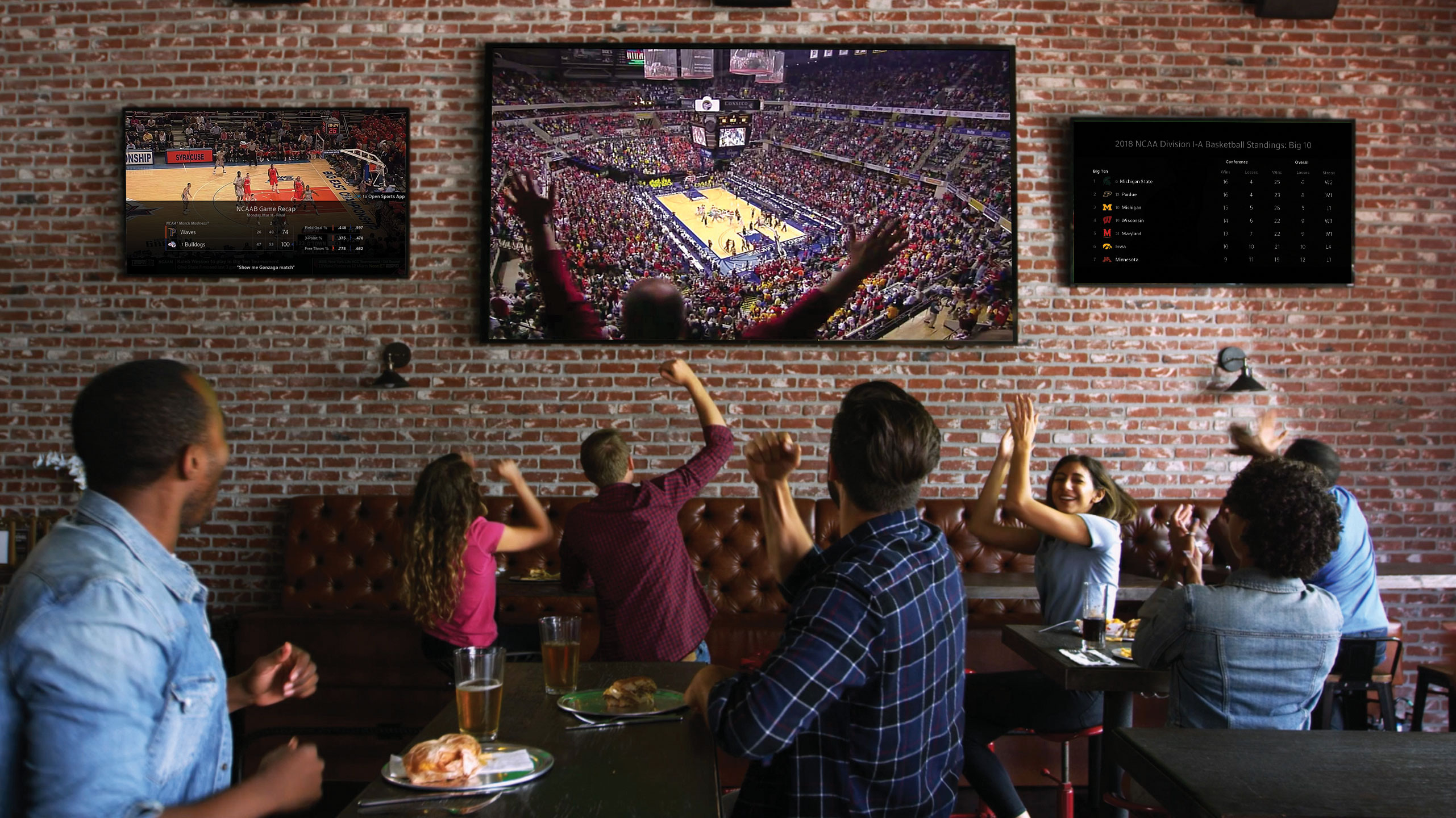 Fans cheer at a bar as they watch a basketball game.