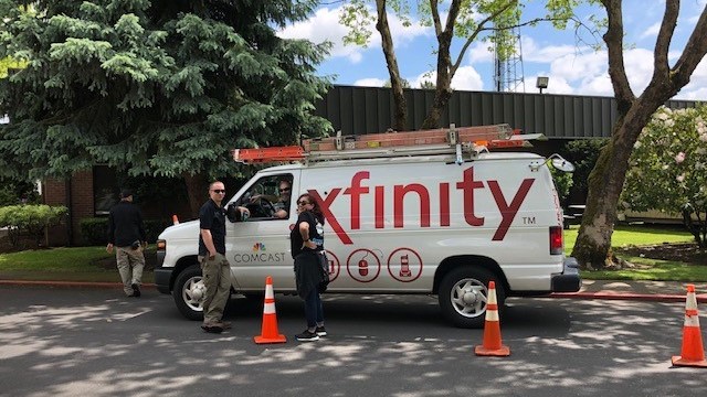 Two people standing in front of a Xfinity work truck