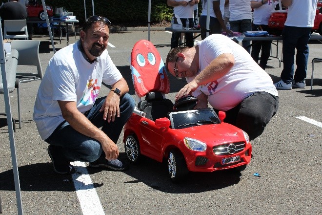 Joe Mitchell poses next to the car he helped build for Go Baby Go event