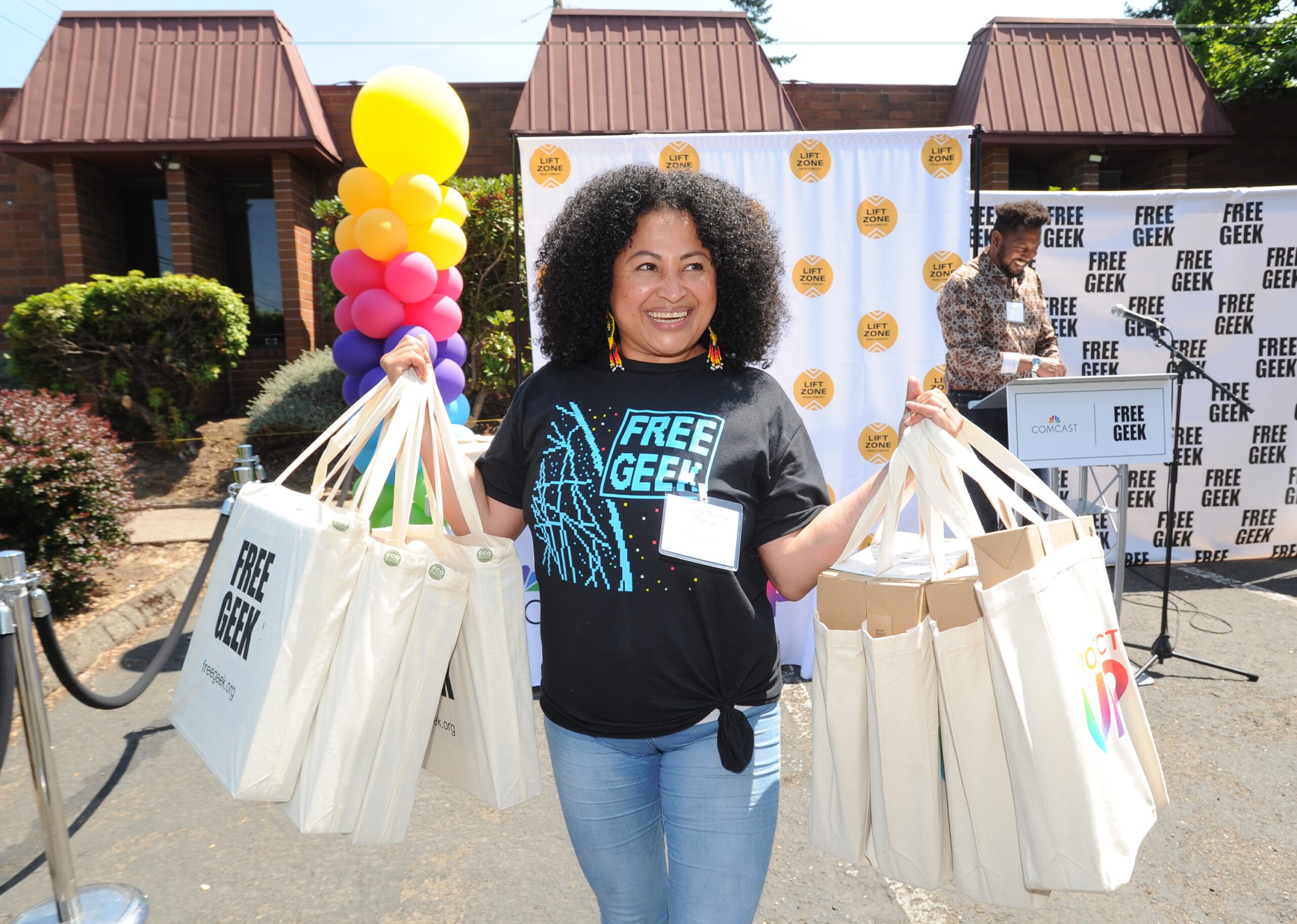 A woman holds laptops in bags.