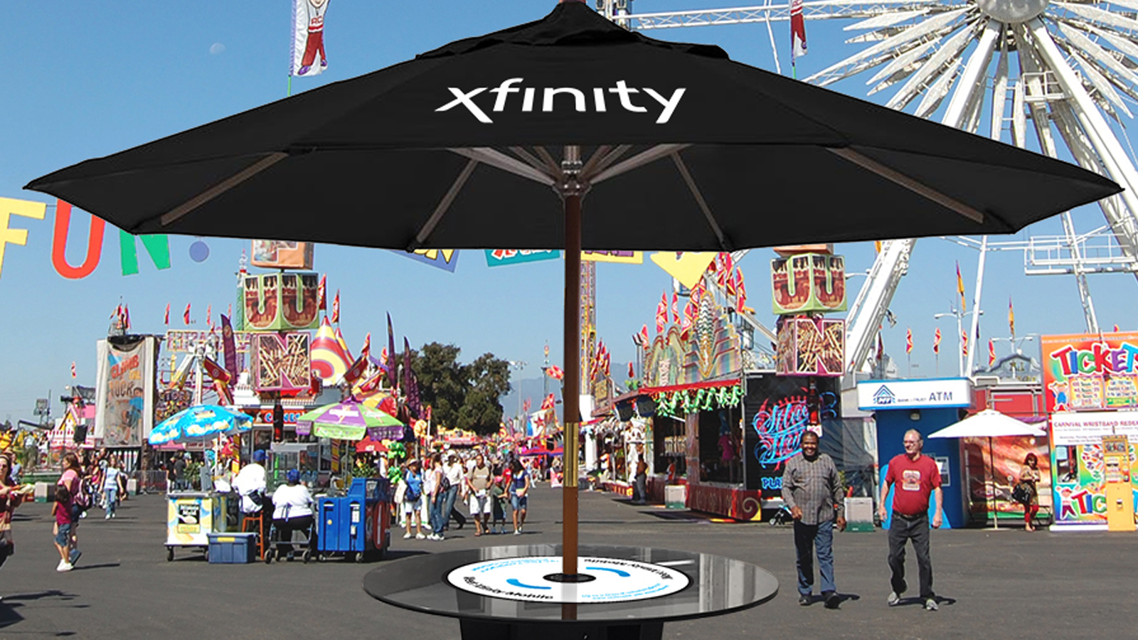 A large sun umbrella displaying the Xfinity logo.