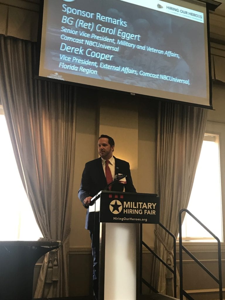 Comcast Florida Region Vice President of External Affairs Derek Cooper onstage at a military hiring fair.